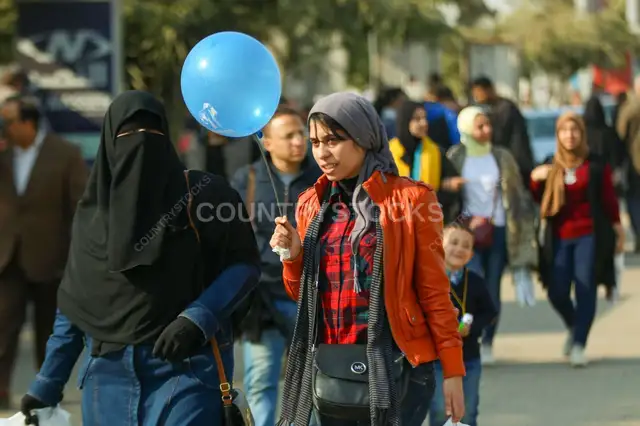 نساء بتمشي مع بالون أزرق في معرض القاهرة الدولي للكتاب 2017