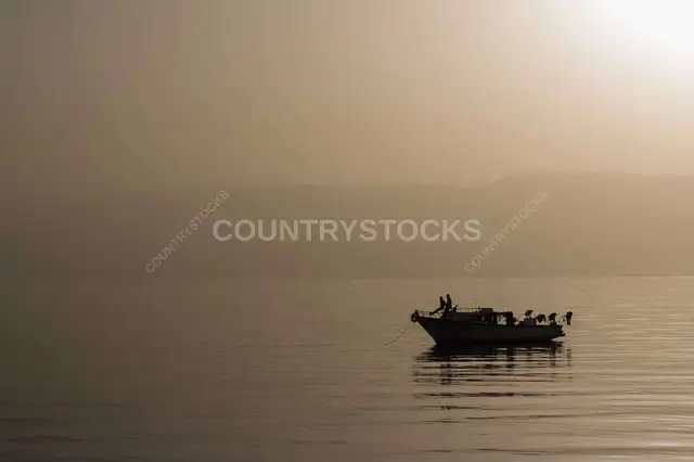 قارب عند الغروب على بحر هادي
