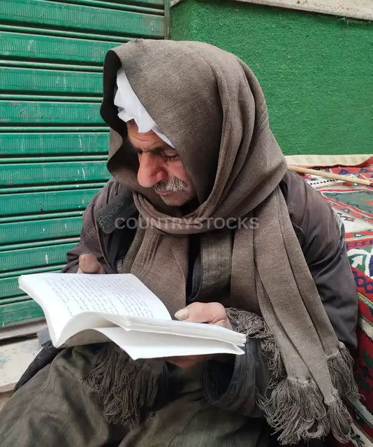 رجل مسن يقرأ كتاباً في حارة درويش بعابدين