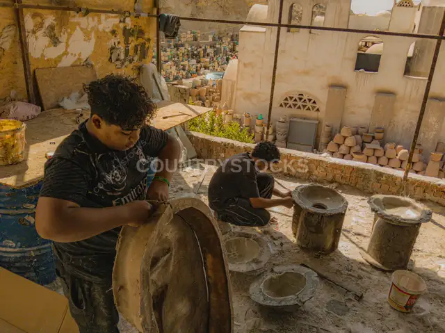 عاملان يشكّلان قوالب فايبر جلاس في ورشة بالقاهرة