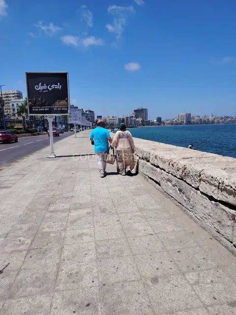 زوجان يمشيان على كورنيش الإسكندرية