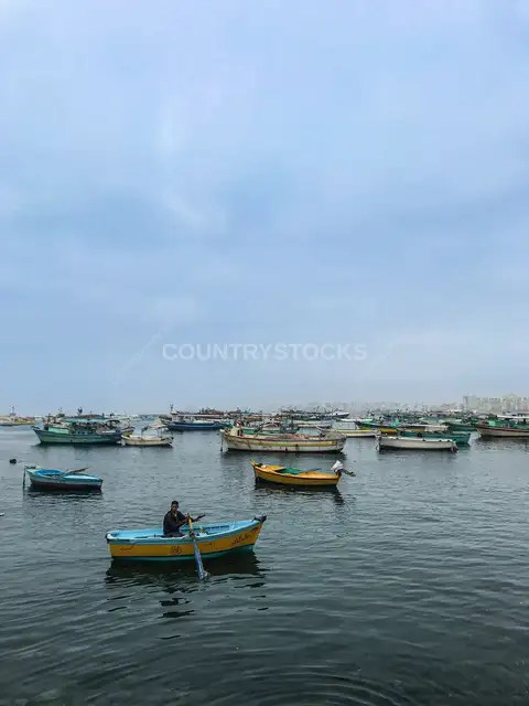 صياد يجدف في قارب خشبي، ميناء الإسكندرية