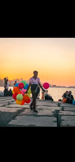 بائع البالونات على كورنيش الإسكندرية عند الغروب