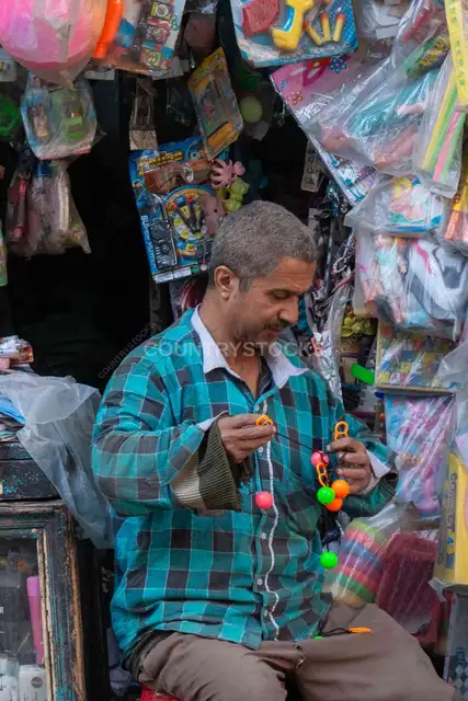 بائع ألعاب يرتب بضاعته في محله بالقاهرة