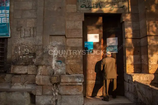 رجل مسن يدخل مسجداً تاريخياً في شارع الأشراف بالقاهرة