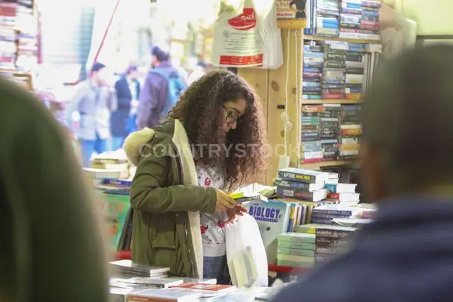 بنت بشعر مجعد بتقرأ كتاب في معرض القاهرة للكتاب 2017 – 2
