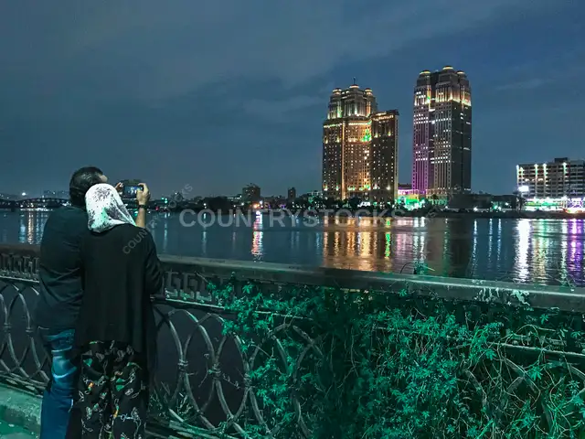 زوجان يصوران أفق كورنيش النيل ليلاً في القاهرة