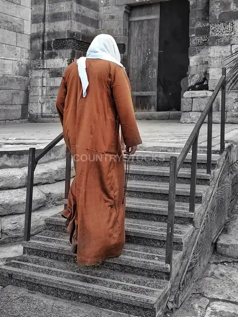 رجل بجلباب يصعد درج مسجد فرج بن برقوق بالقاهرة