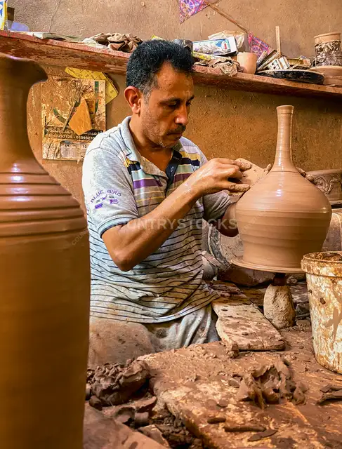 صانع فخار يشكّل إبريق طين في قرية الفرستق، طنطا