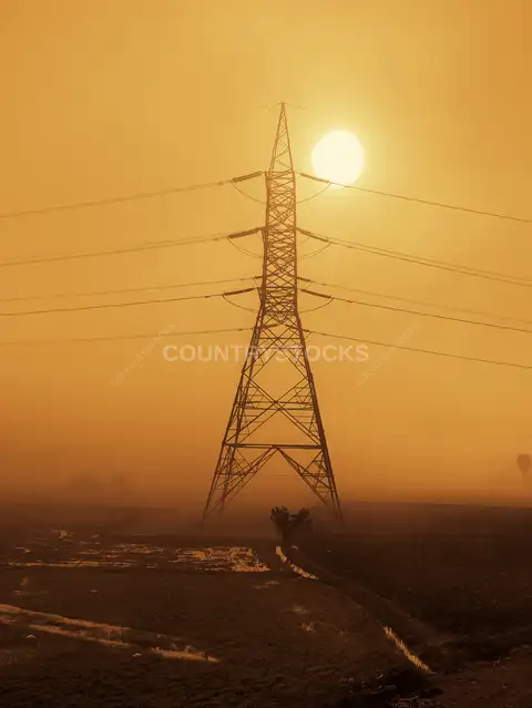 High Voltage Electricity Pylon at Sunrise, Egyptian Countryside