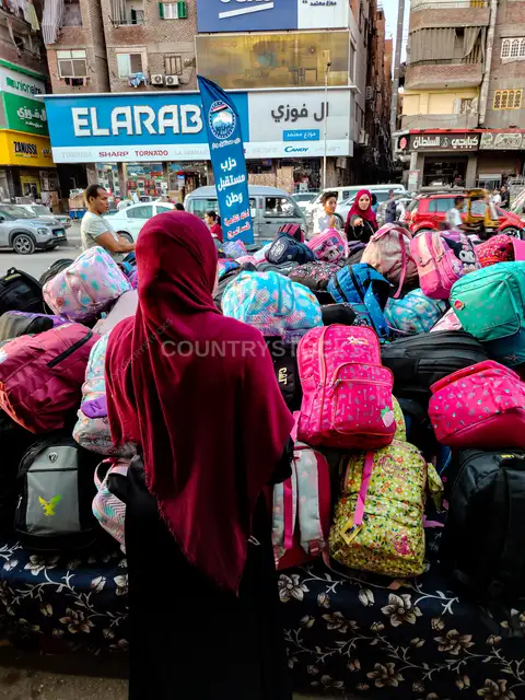 امرأة تختار شنطة مدرسية في سوق الشرفا بالقاهرة