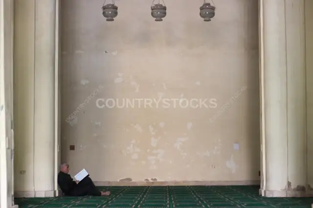 A man reads the Qur'an inside the historic Al-Hakim Mosque in Cairo.
