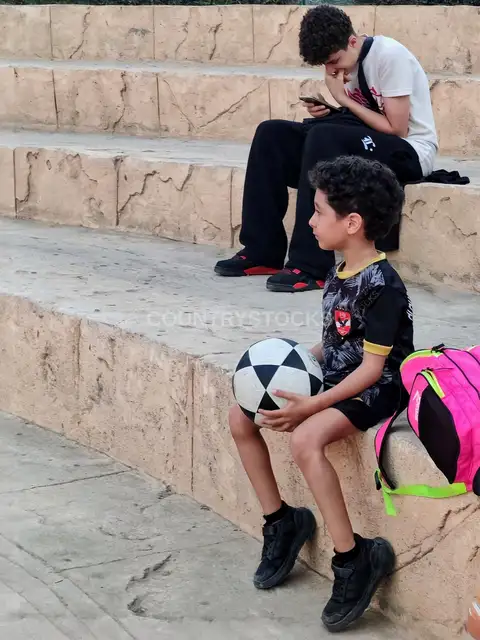 Egyptian Boy Holding Soccer Ball on Stone Steps