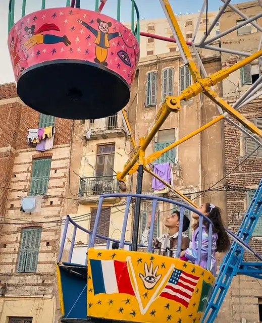 طفلين بيركبوا مرجيحة المولد في العيد
