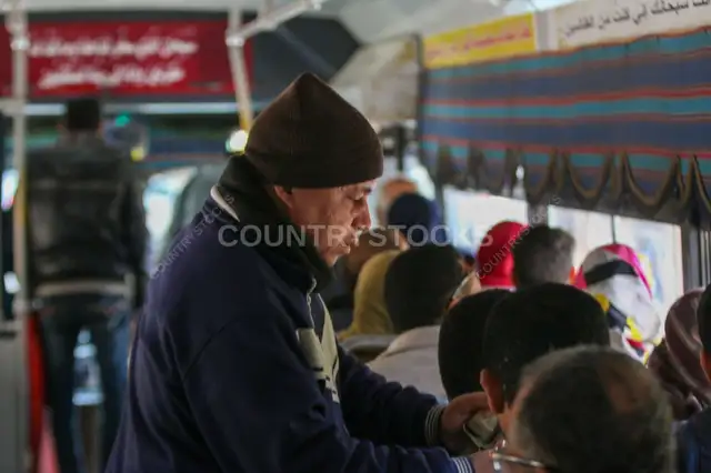 راجل في منتصف العمر واقف جوه أتوبيس في القاهرة