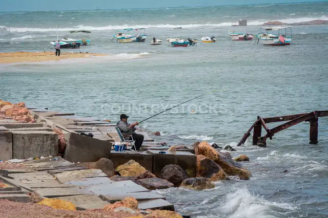 Man Fishing on Concrete Pier, Alexandria Coast