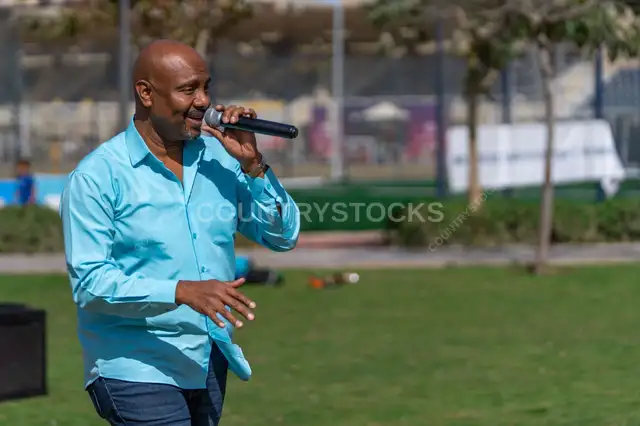 A person singing at a Christmas celebration in a garden during the day