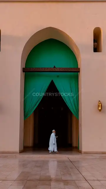 رجل بالجلباب الأبيض يدخل بوابة مسجد، القاهرة
