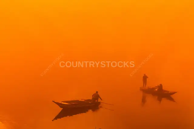 Fishermen Rowing Wooden Boats in Dense Orange Fog