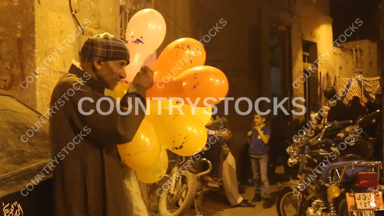 رجل مسن ينفخ البالونات ويبيعها للأطفال في القاهرة، مصر – فيديو
