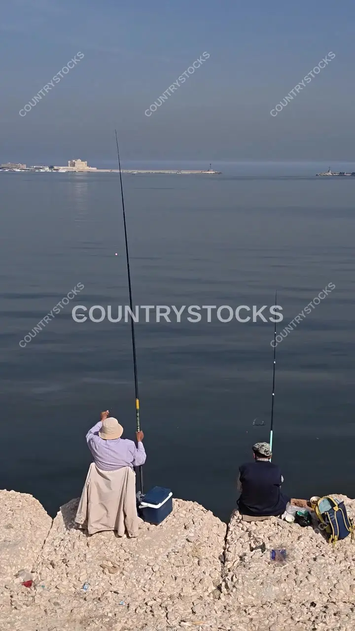 Fishermen on Alexandria Corniche with Qaitbay Citadel on the Horizon