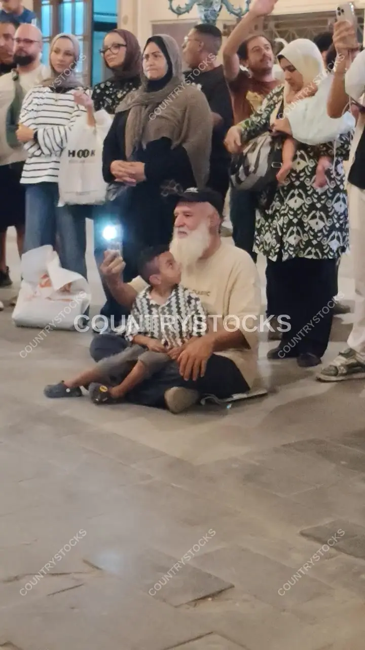 Elderly Man with Child Amid Public Crowd, Cairo