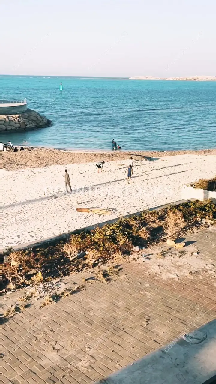 أب وأبناؤه يلعبون كرة القدم على شاطئ مرسى مطروح