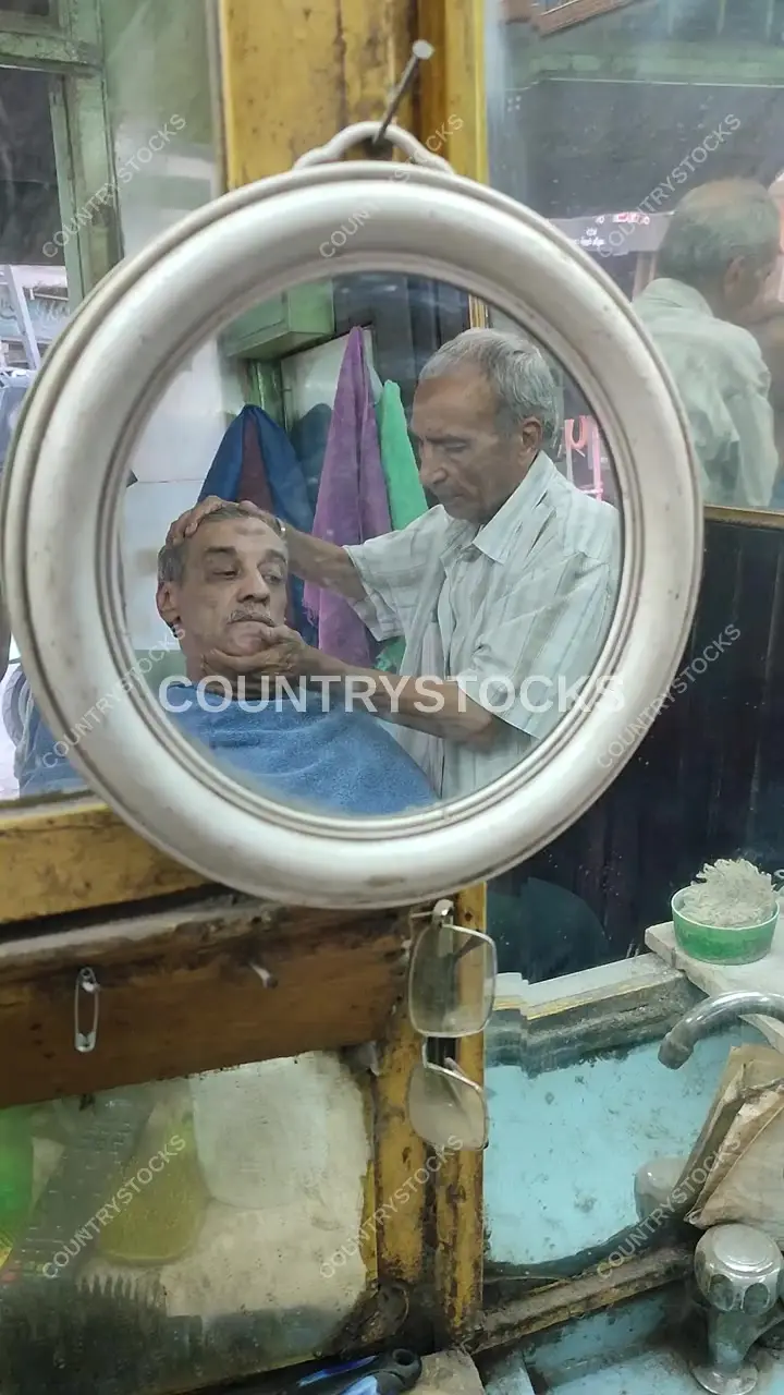 حلاق مصري تقليدي ينعكس في مرآة دائرية